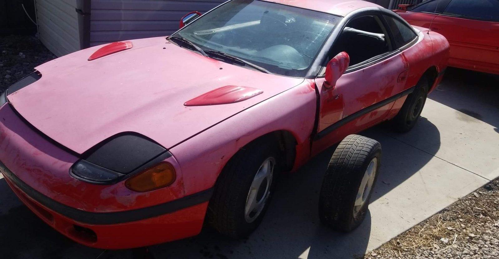 Red 1991 Dodge Stealth with a black front bra in a driveway